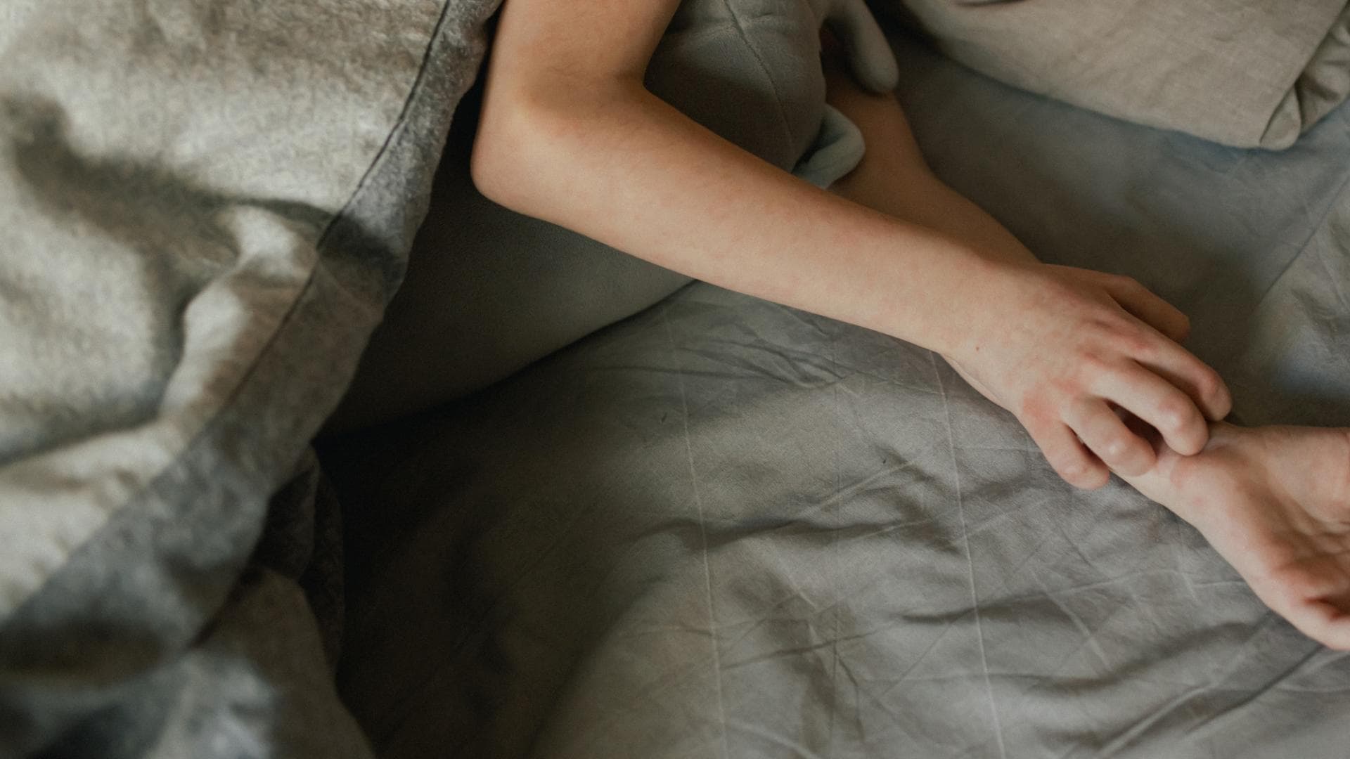 Juckreiz an den Händen, während die Person im Bett liegt