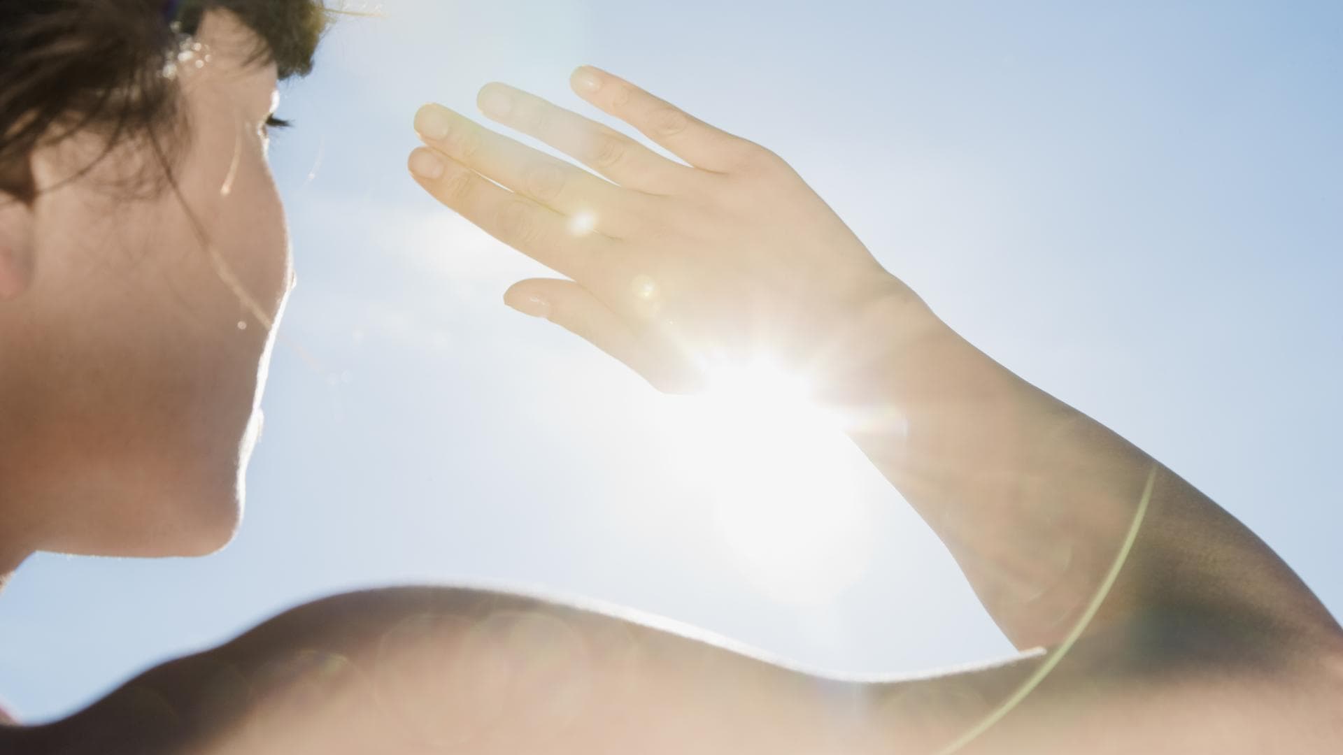 Klimaresilienz ist eine Eigenschaft, die immer wichtiger wird Eine Frau schützt sich mit der Hand vor der Sonne