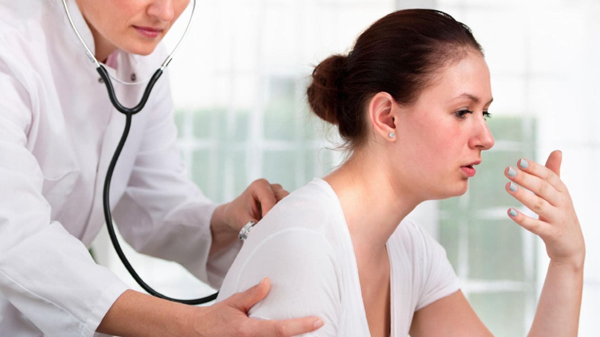 Ärztin horcht Patientin ab Husten und Bronchitis