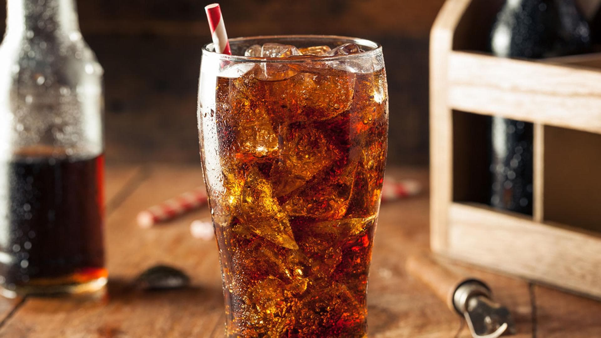 Ein Glas Cola mit Eiswürfeln und Strohhalm Ein Glas Cola mit Eiswürfeln und Strohhalm