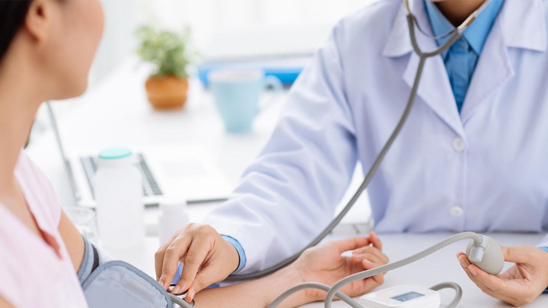 Arzt misst Blutdruck bei Patientin