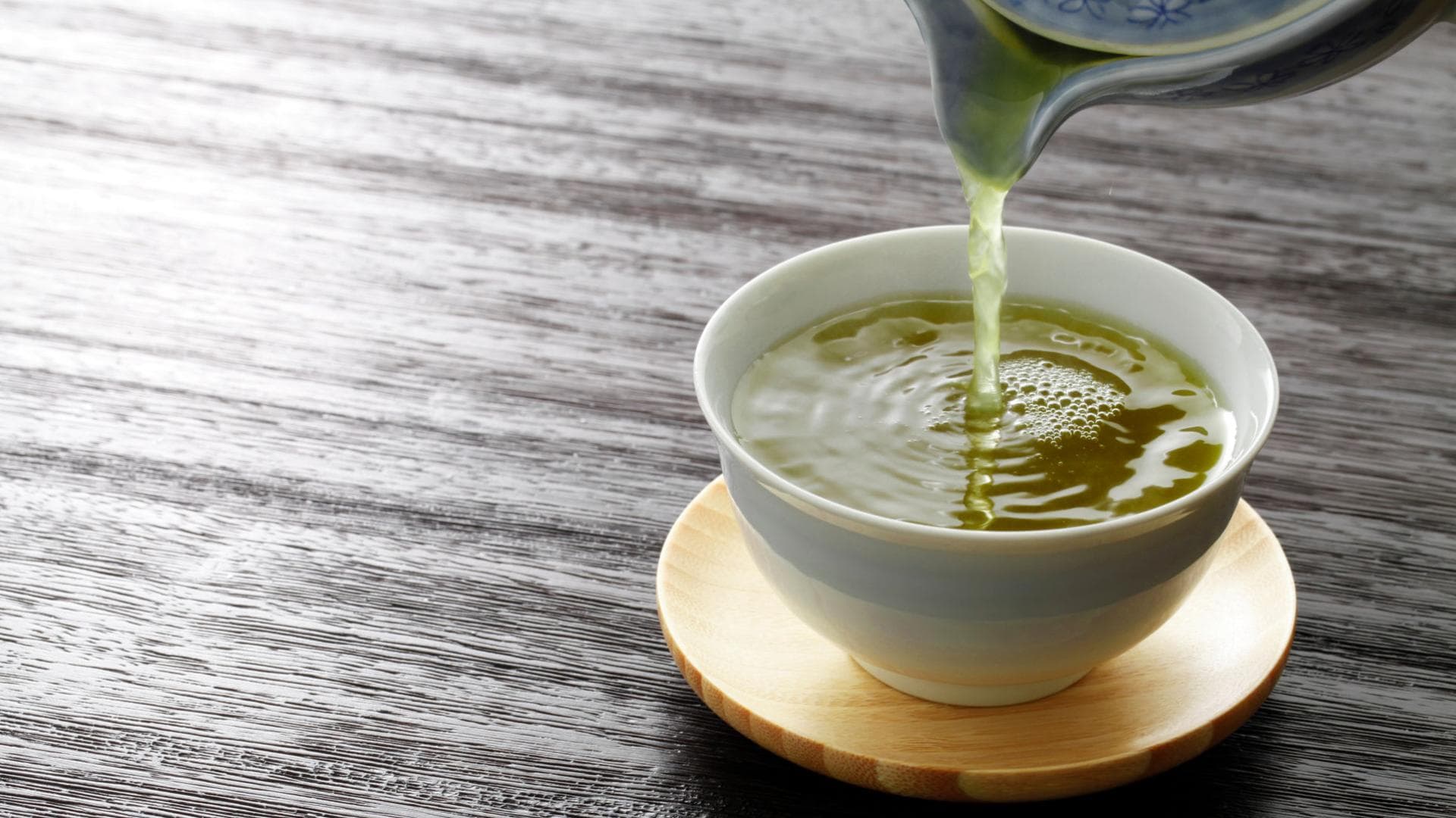 Grüner Tee wird in eine Tasse gegossen