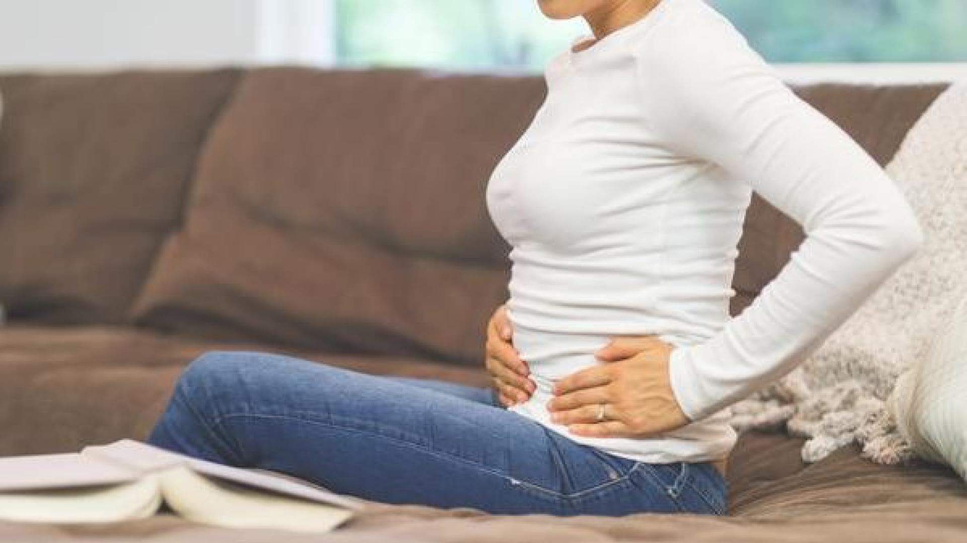 Frau hält sich die Hände vor dem Bauch.