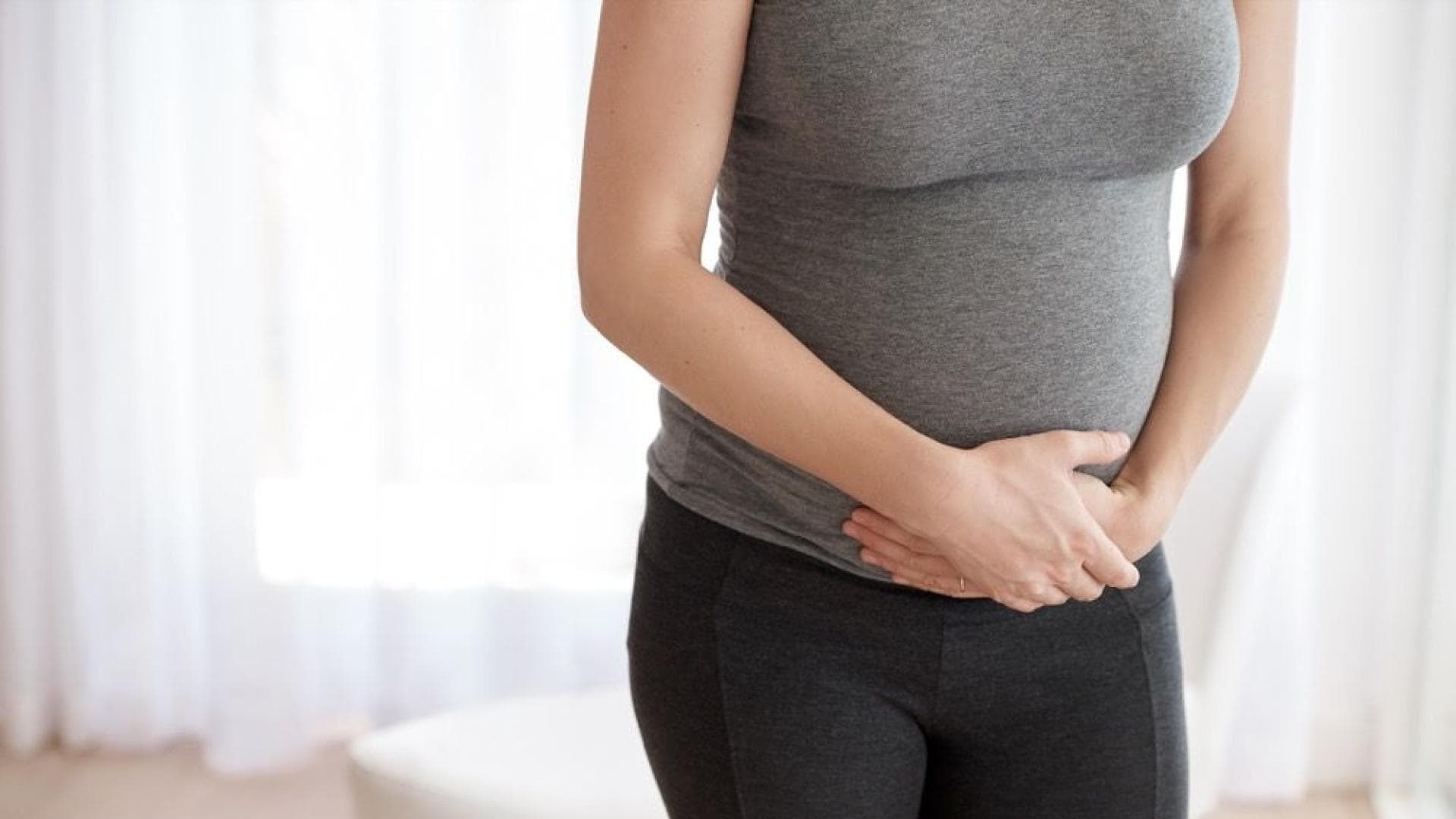 Schwangere-Frau-haelt-sich-die-Haende-vor-dem-Bauch Schwangere Frau hält sich die Hände vor dem Bauch.