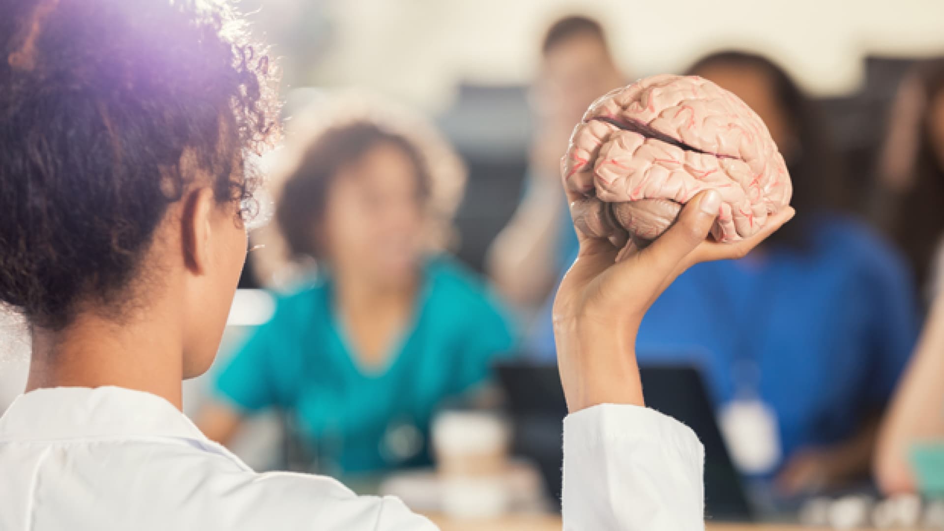 Die häufigste Form von Demenz ist die Alzheimer-Krankheit. Frau hält Modell eines Gehirns in der Hand