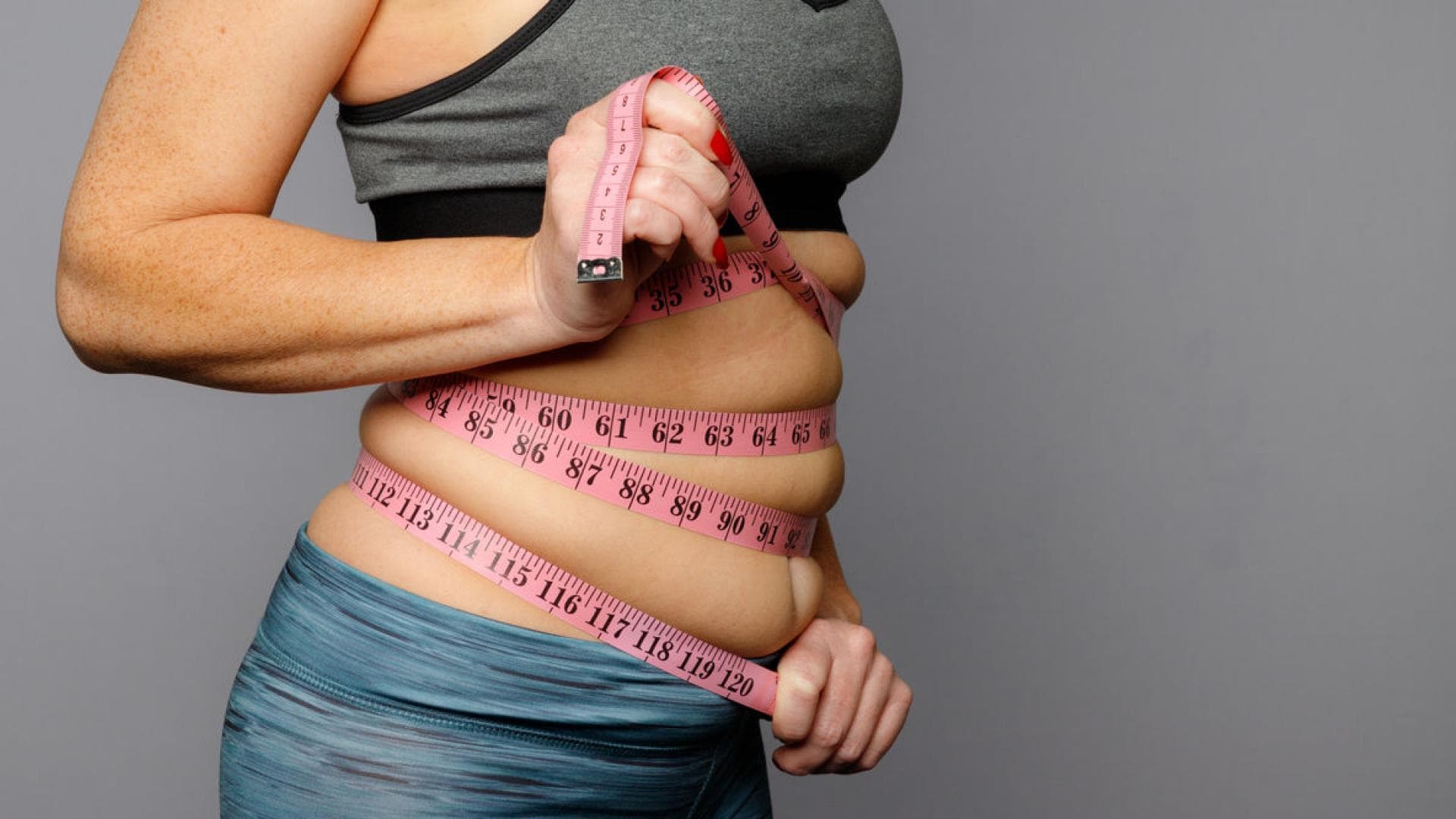 Frau mit Maßband um den Bauch