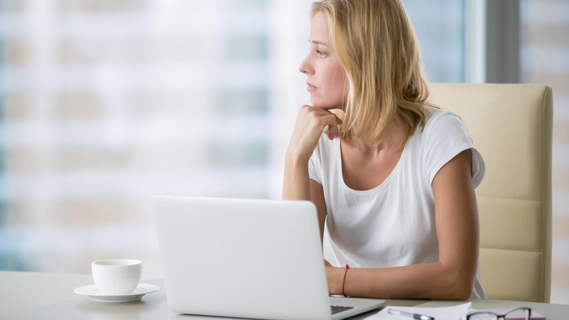 Frau am Laptop nachdenklich unkonzentriert