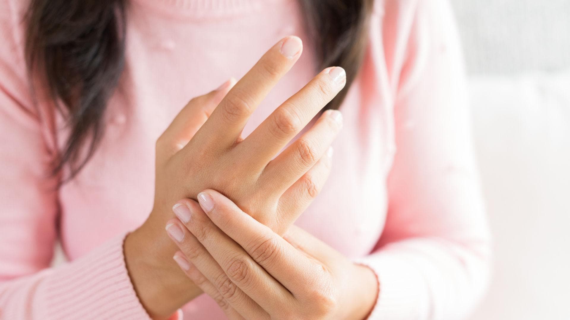 Frau hält sich die Hand