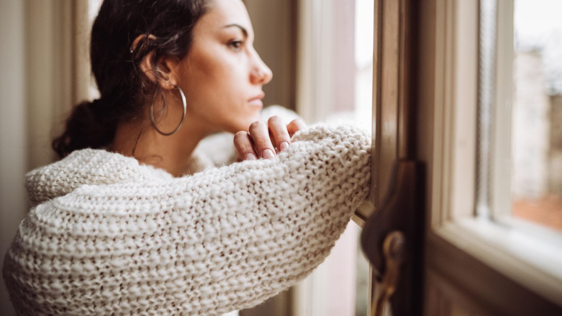 Frau steht am Fenster