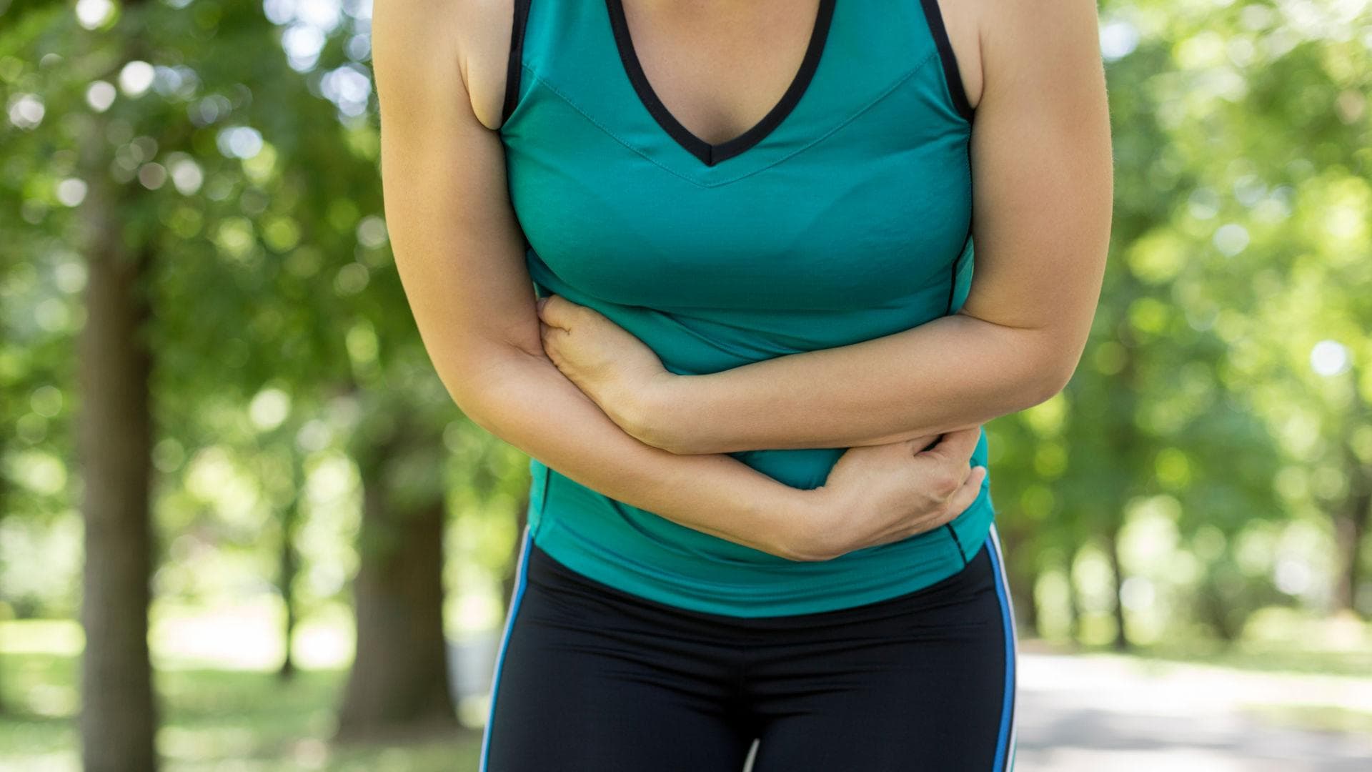 Frau beim Sport mit Bauchschmerzen