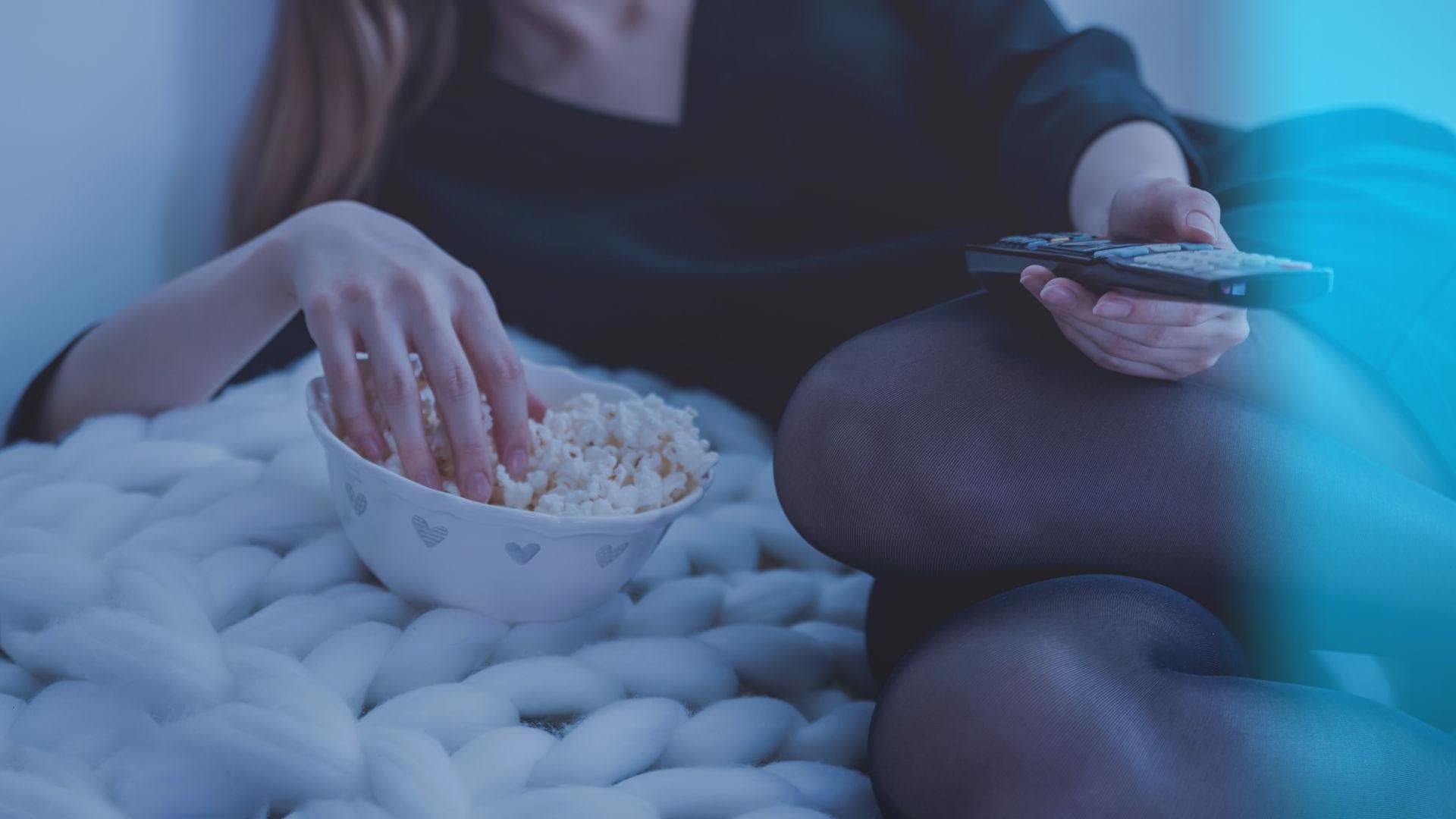 Frau guckt TV mit Popcorn