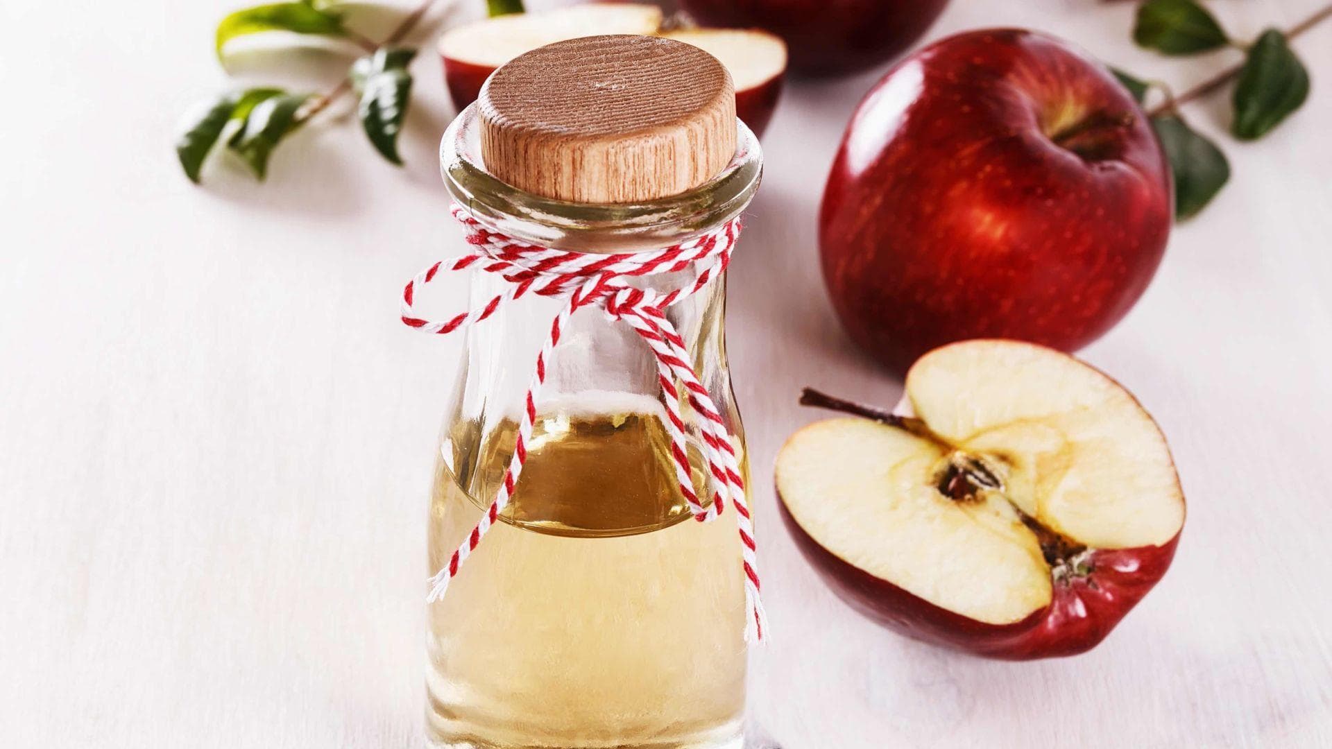 Flasche mit Apfelessig und Äpfel