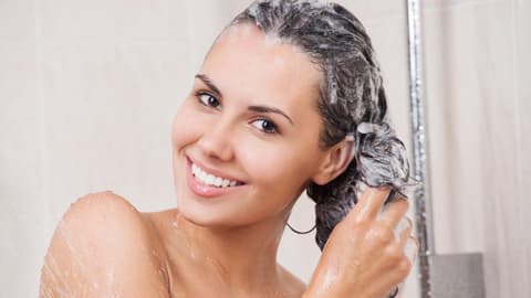 Frau wäscht sich die Haare