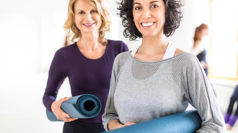 Zwei ältere Frauen mit Sportmatten