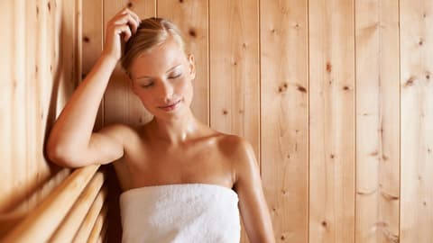 Eine Frau sitzt in der Sauna