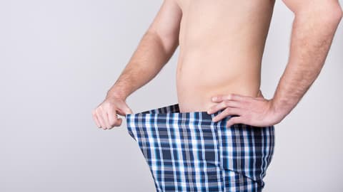 Mann begutachtet seinen Intimbereich