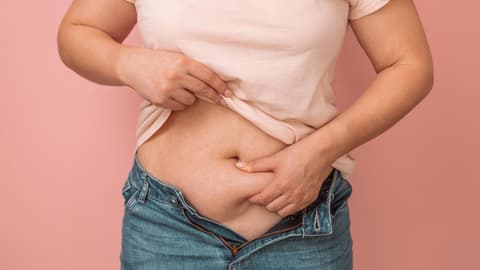 Eine Frau fässt ihren Bauch an
