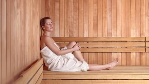Eine Frau sitzt in der Sauna