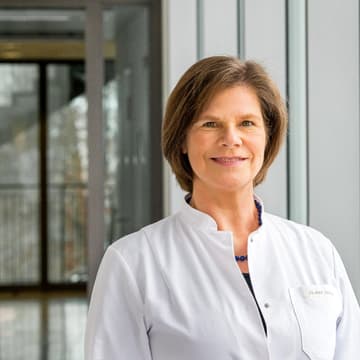 Prof. Dr. Ulrike Protzer (braune, kinnlange Haare) lächelt freundlich in die Kamera