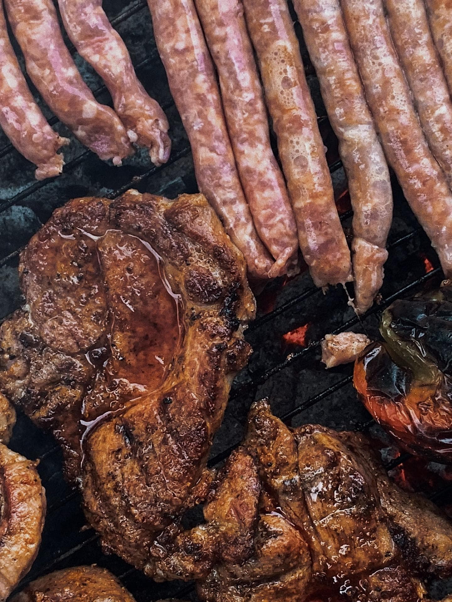 Würstchen, Fleisch und Paprika auf dem Grill.