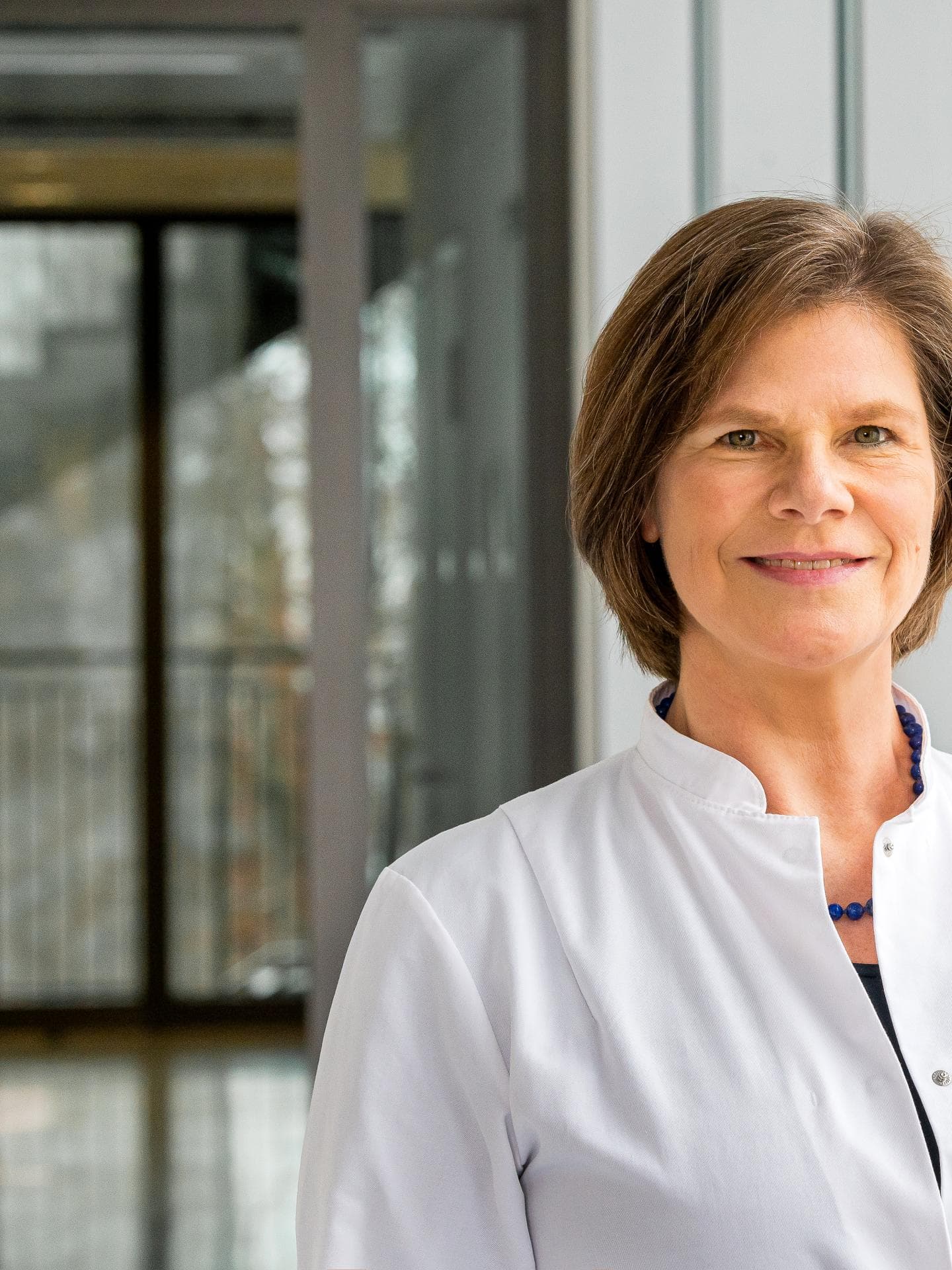 Prof. Dr. Ulrike Protzer (braune, kinnlange Haare) lächelt freundlich in die Kamera