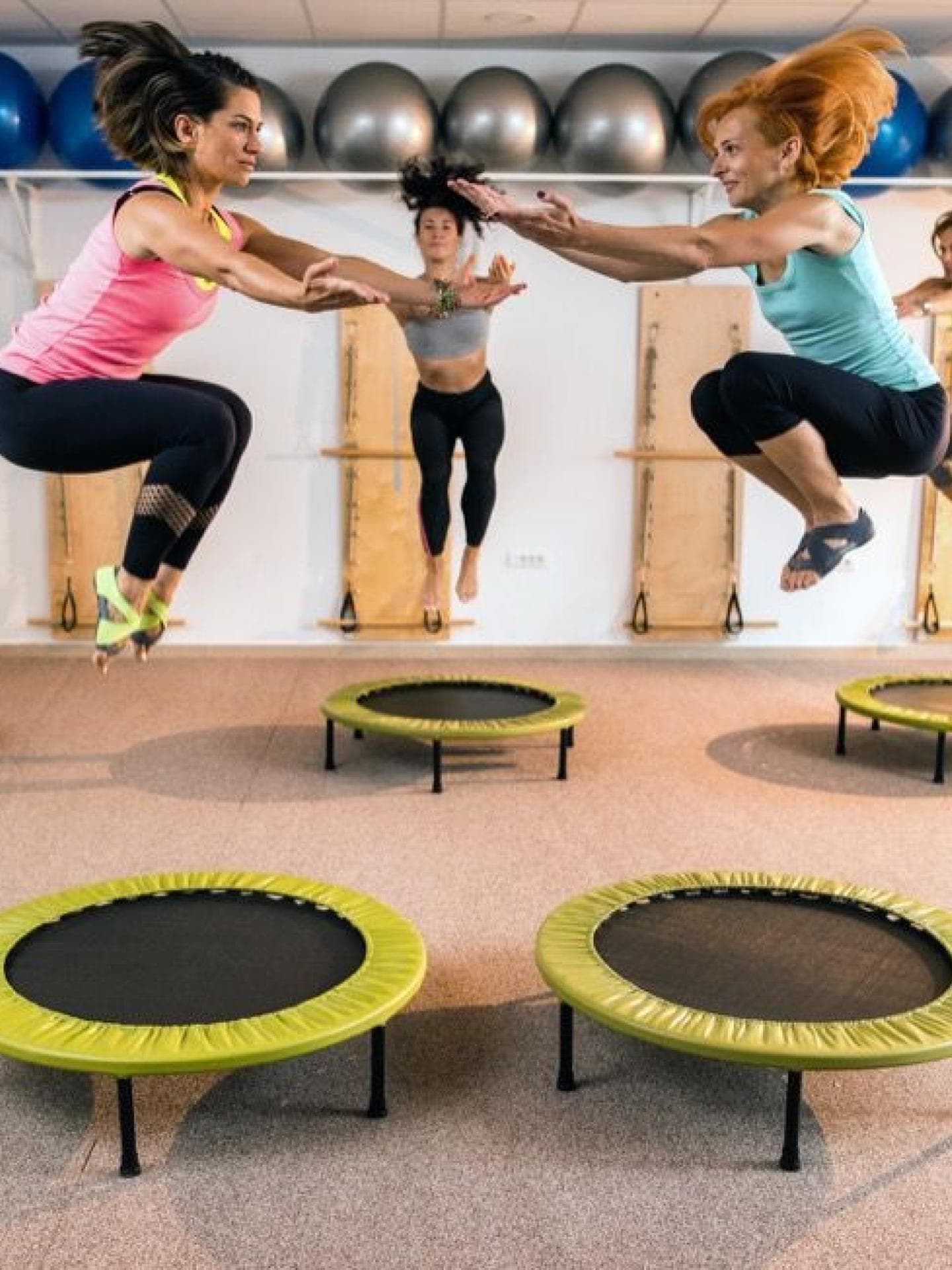 Frauen hüpfen auf einem Trampolin.