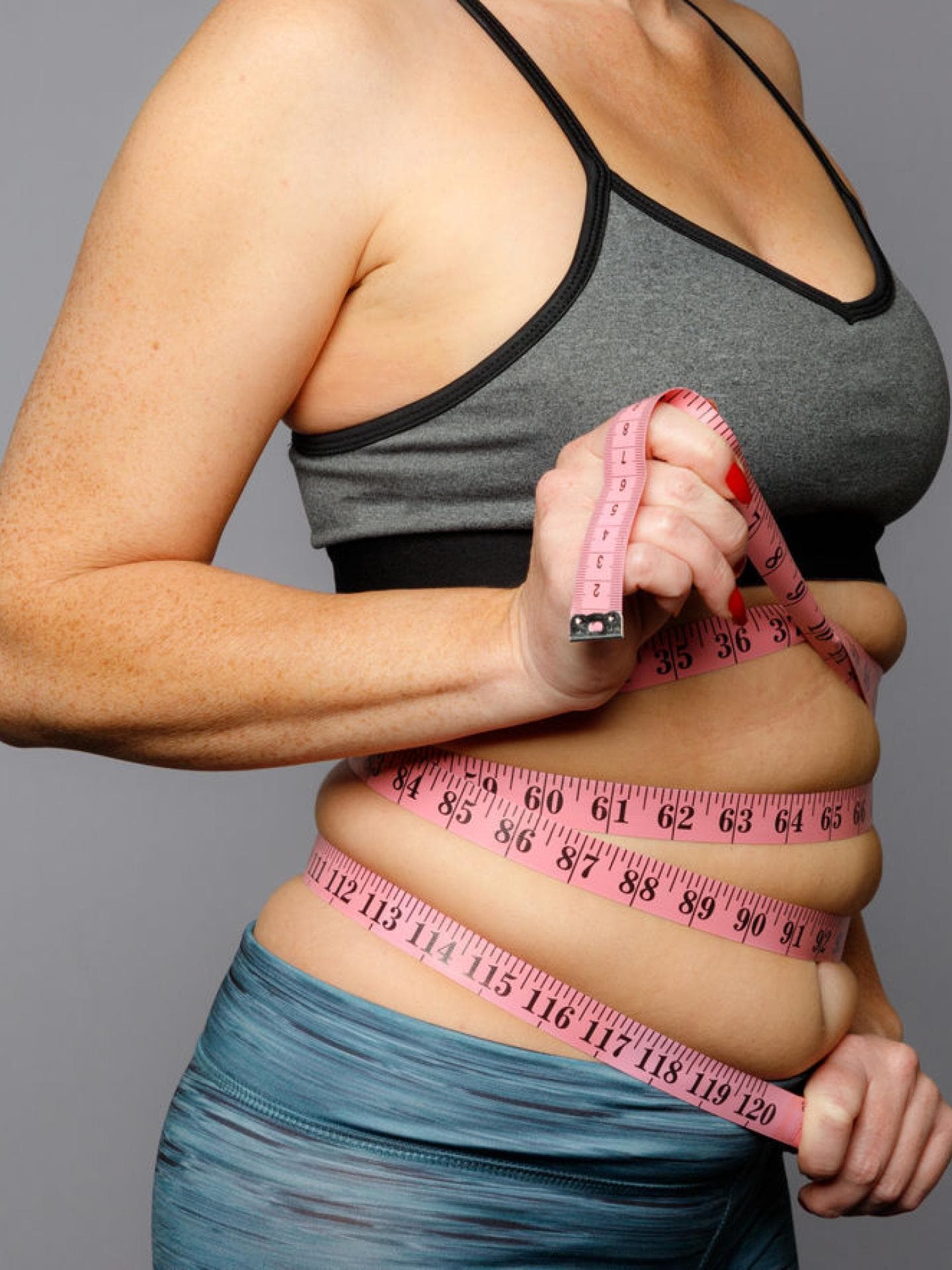 Frau mit Maßband um den Bauch