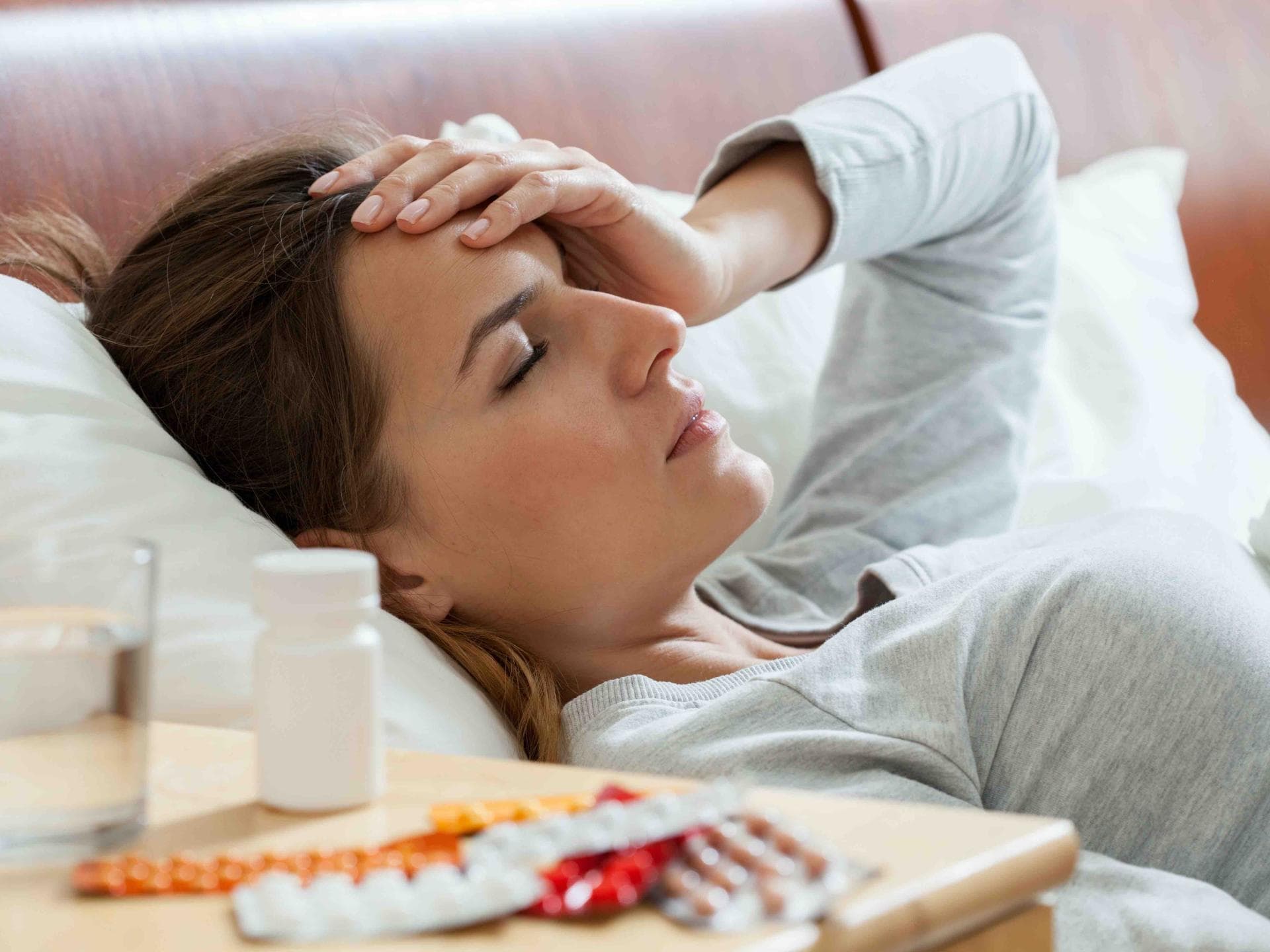 Frau liegt krank im Bett