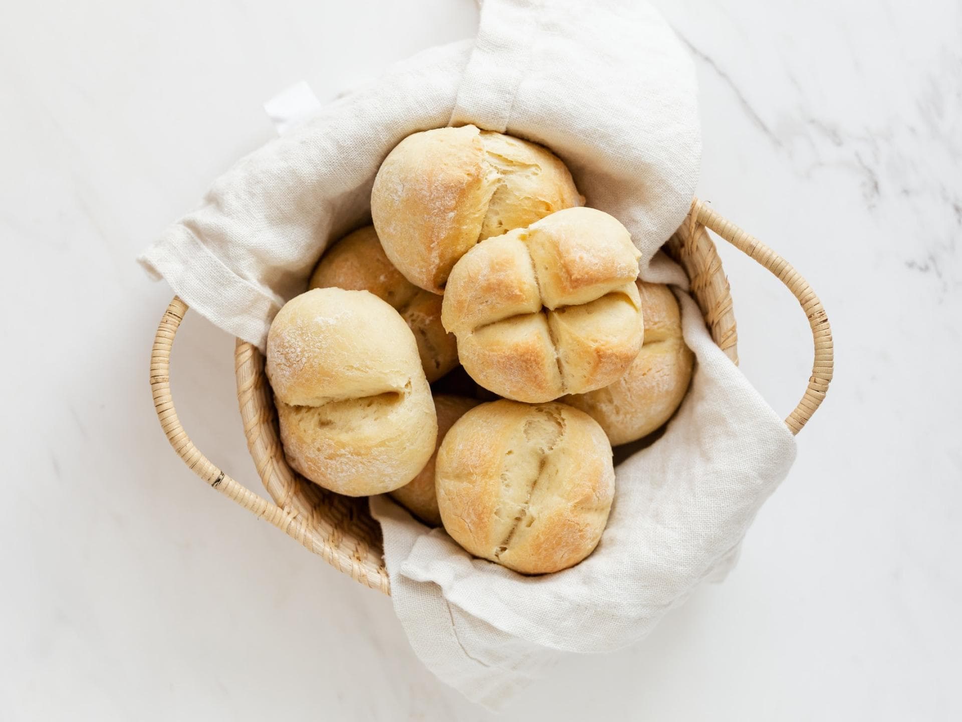 Fluffig und lecker, aber der Nährwert ist gering Weiße Brötchen in einem Korb