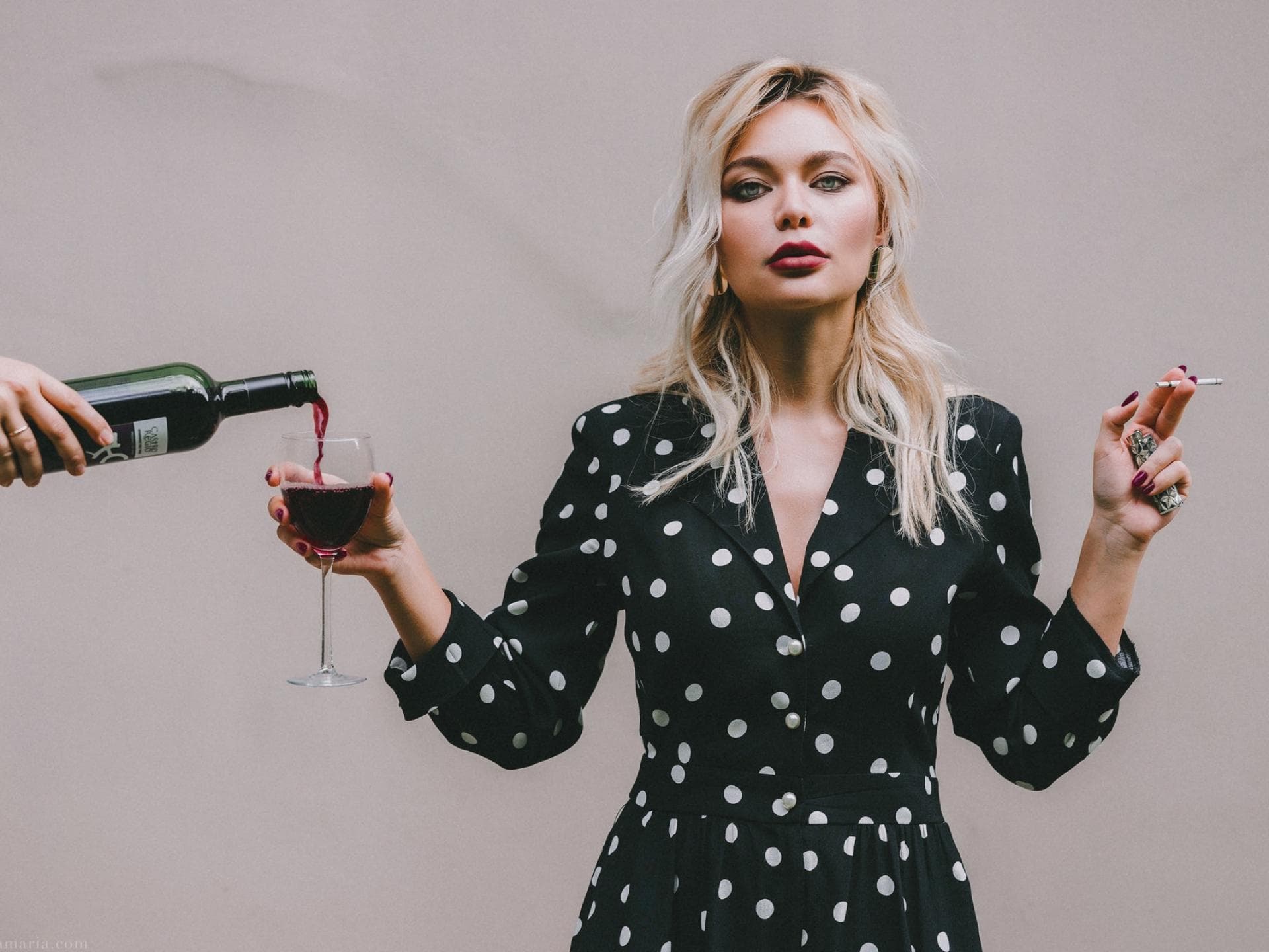 Frau mit Glas Rotwein und Zigarette in der Hand