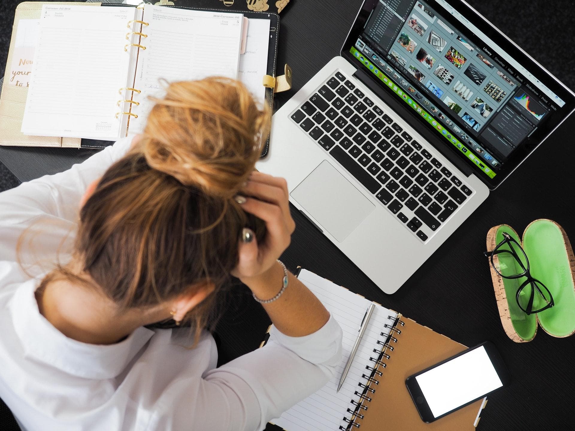 Ein großes Problem ist auch die mangelnde Wertschätzung. Arbeiten, die man nicht sieht, werden nicht anerkannt. Frau sitzt am Schreibtisch und vergräbt ihr Gesicht in den Händen