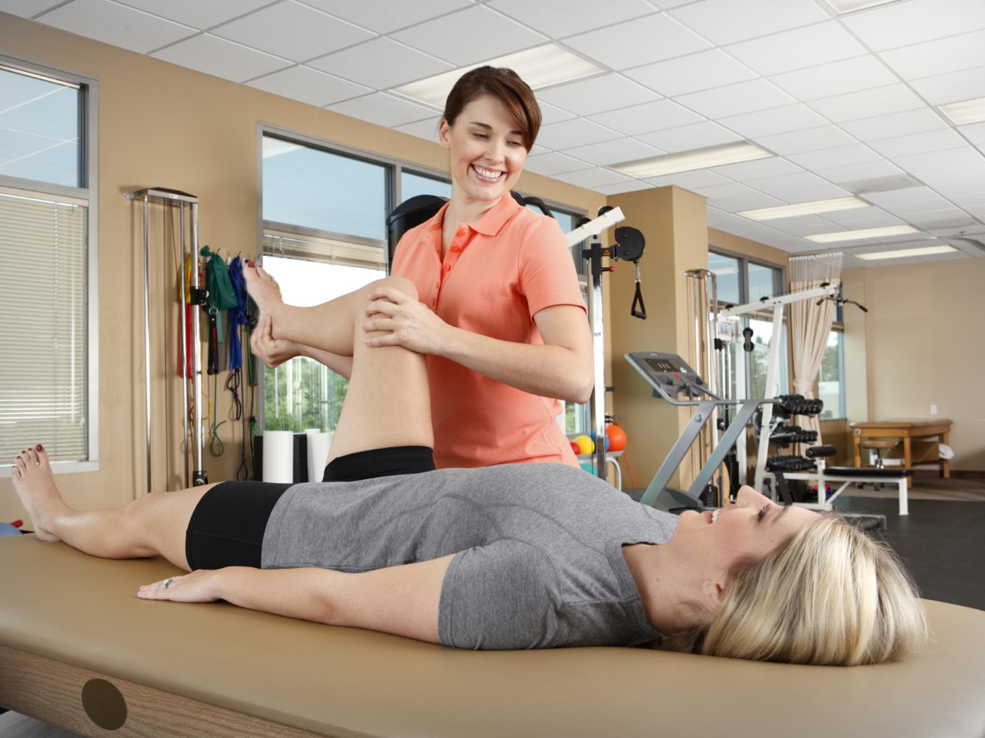 Physiotherapeutin behandelt das Bein einer Patientin