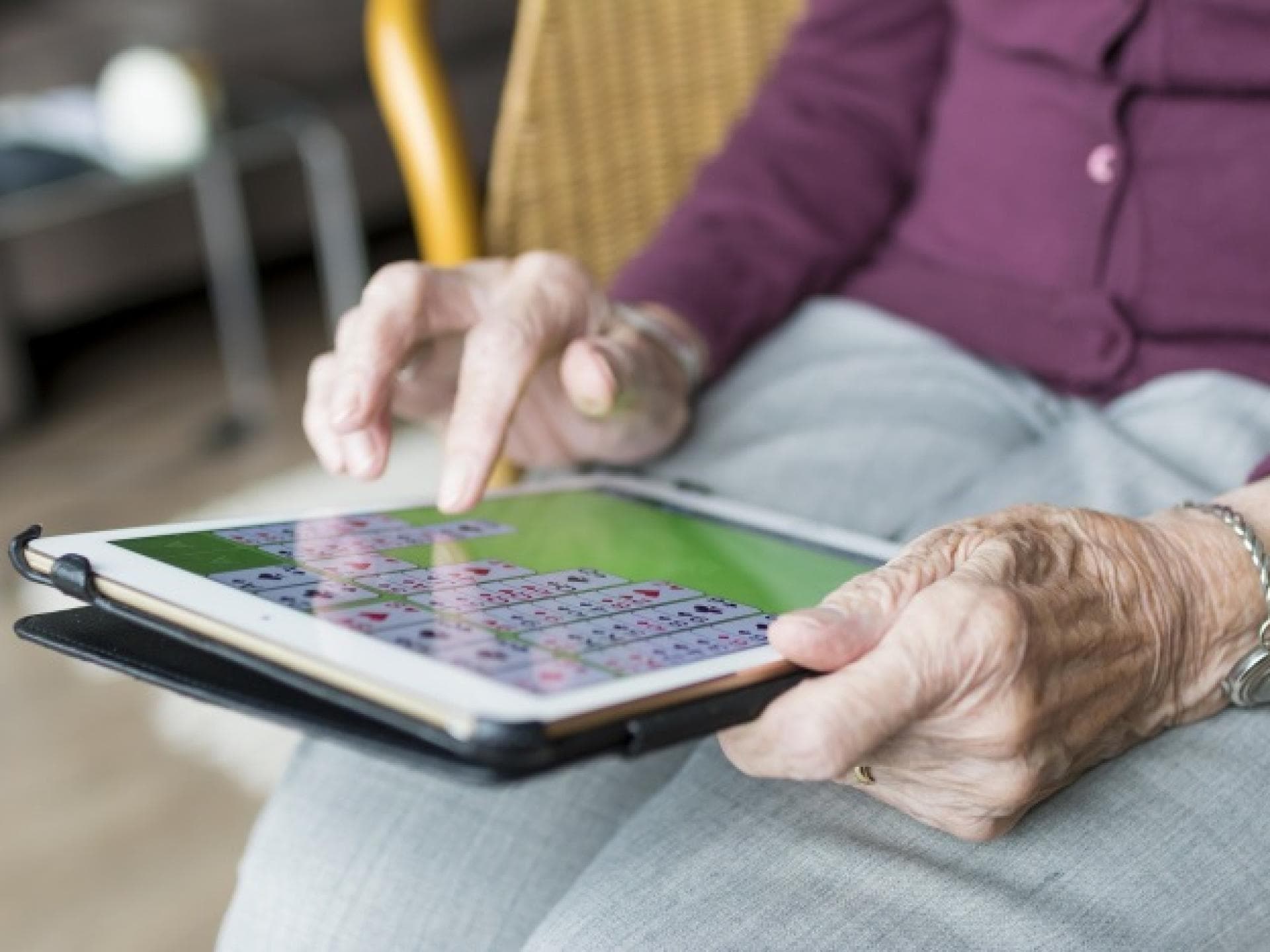 Ältere Frau tippt auf Tablet