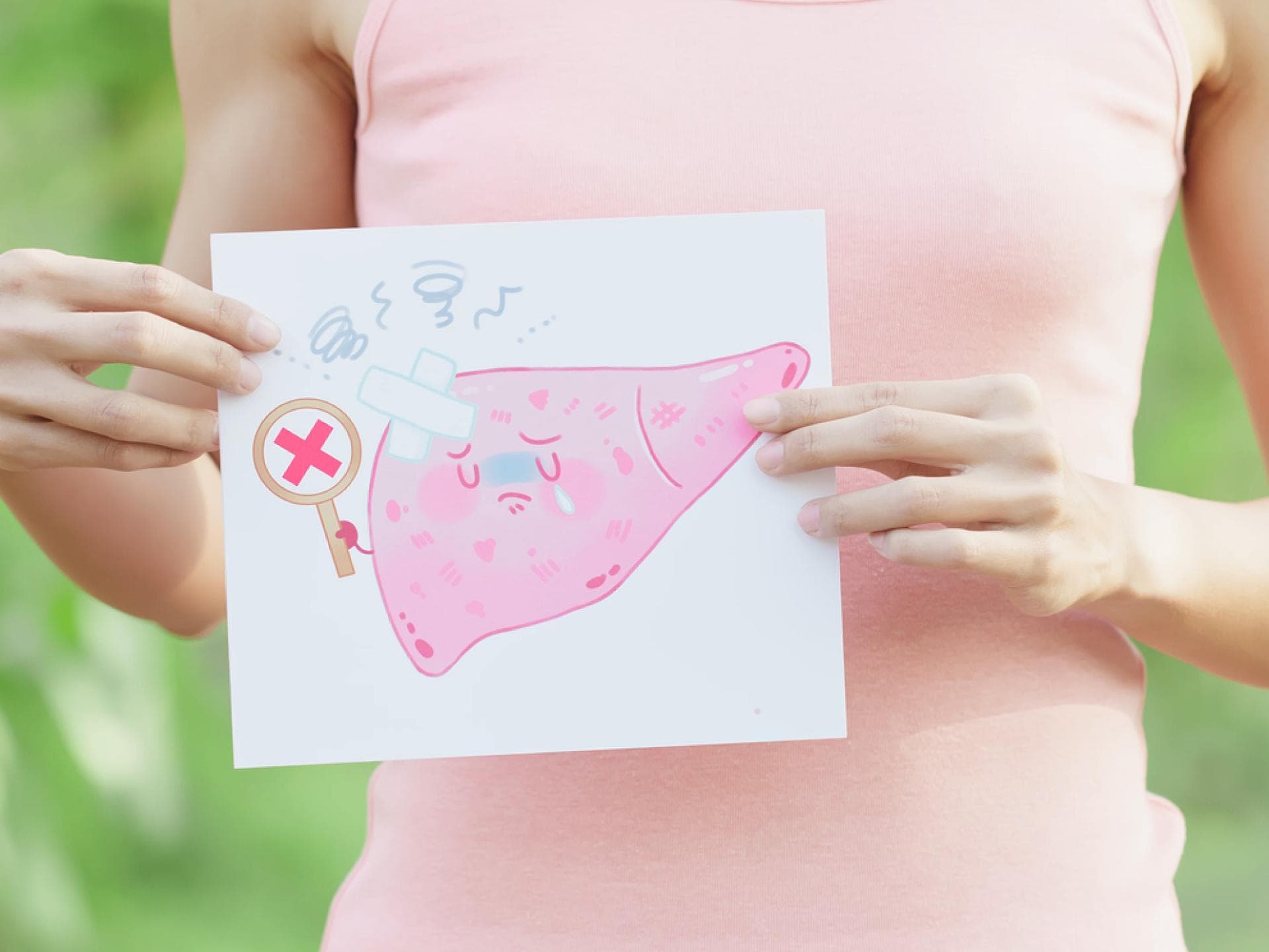 Frau hält Grafik einer kranken Leber in den Händen Frau hält Grafik einer kranken Leber in den Händen