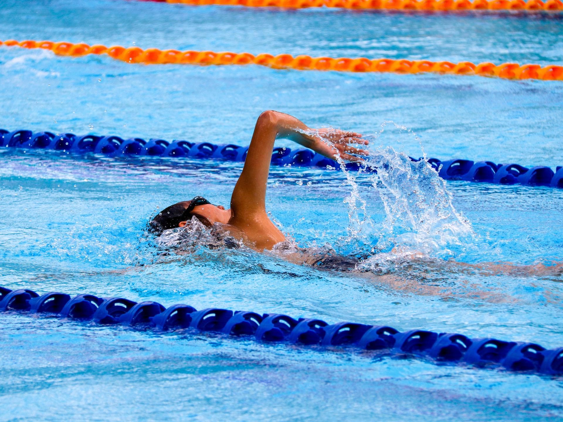 Person schwimmt im Schwimmbad