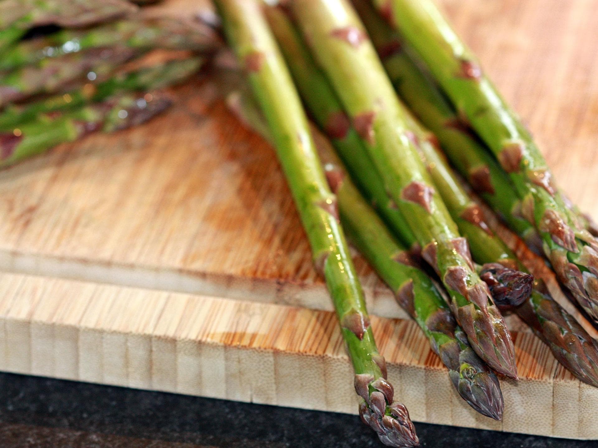 gekochter grüner Spargel auf Holzbrett