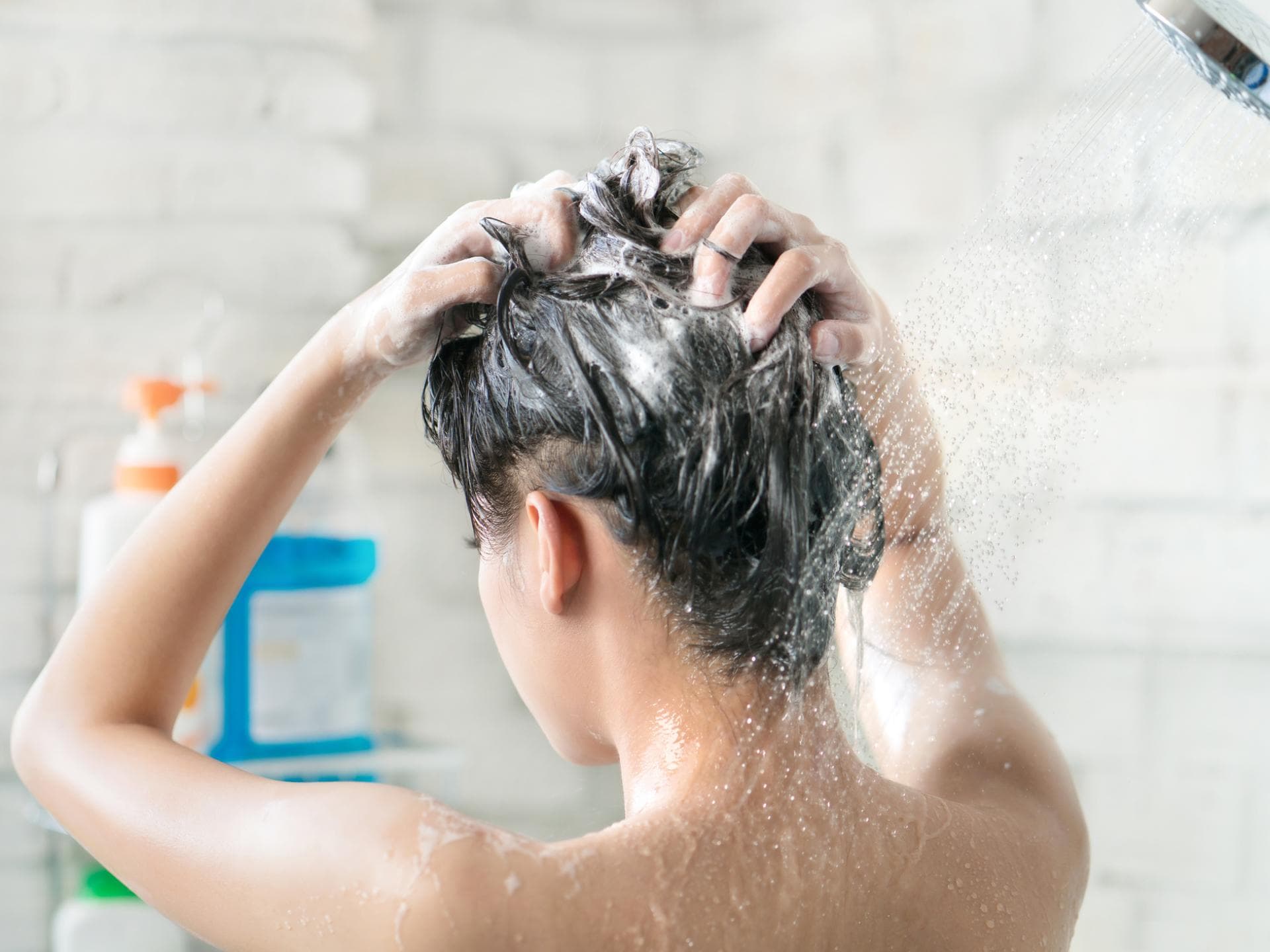 Frau wäscht ihre Haare mit Shampoo