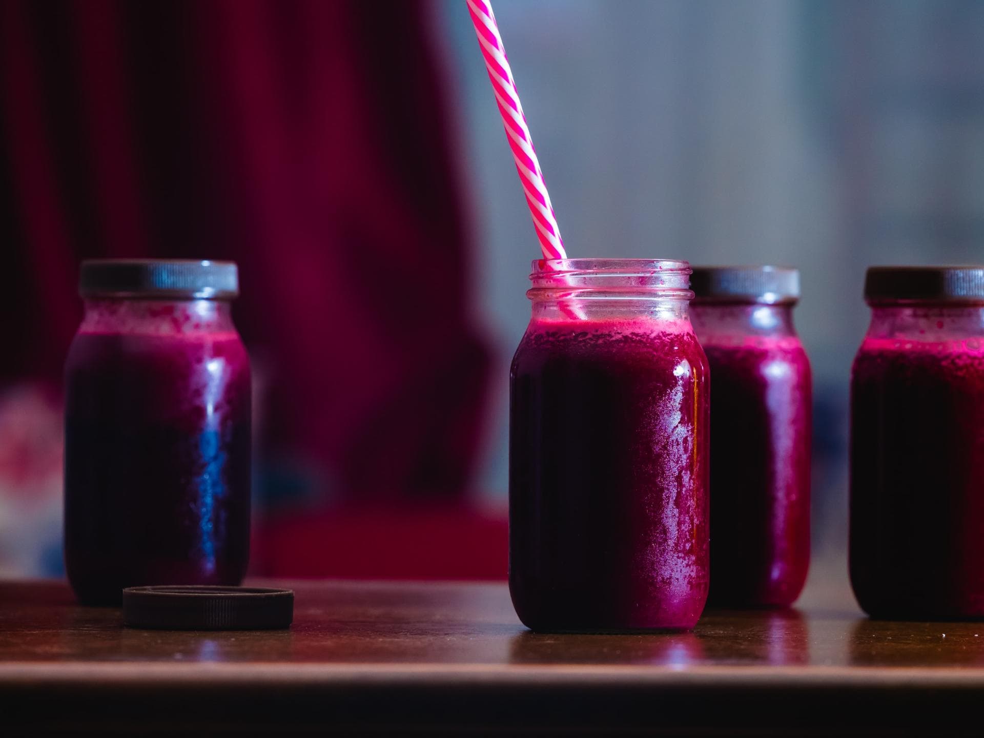 Rote-Beete-Saft in Einmachgläsern mit Strohhalm