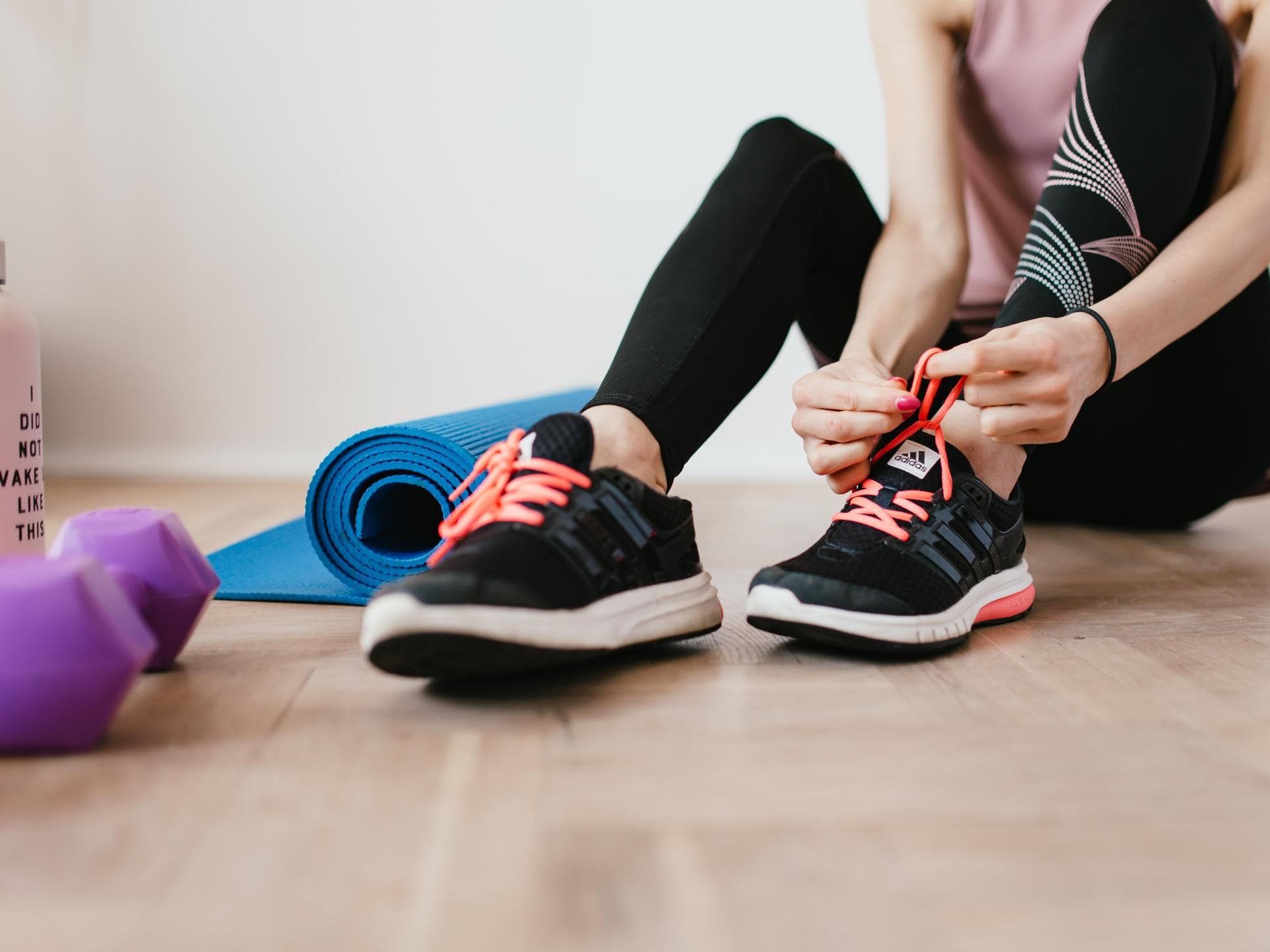 Frau bindet Sportschuhe zu