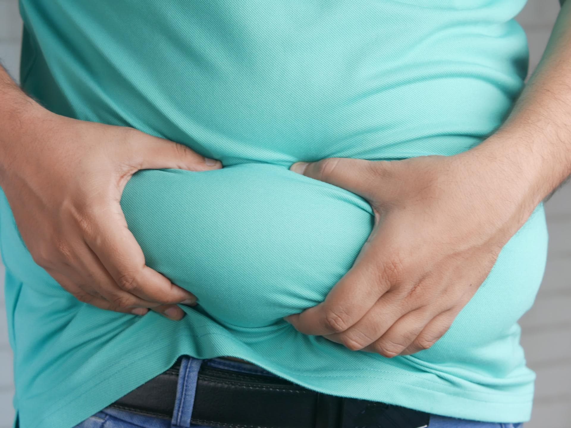 Mann greift sich an den dicken Bauch
