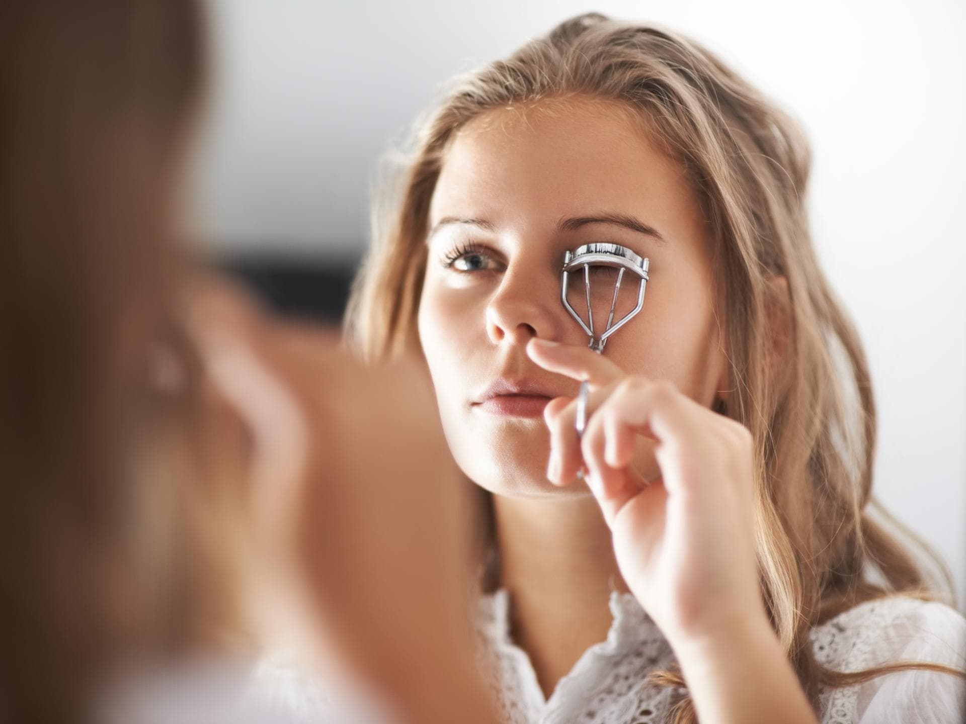 Frau benutzt Wimpernzange