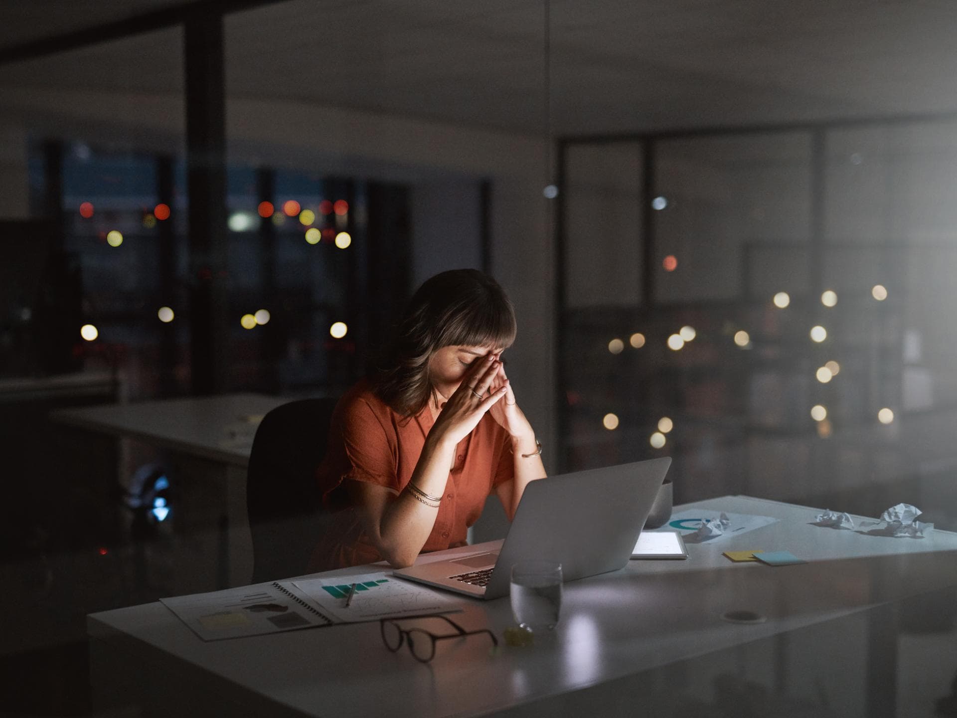 Gestresste Frau, die nachts im Büro arbeitet Gestresste Frau, die nachts im Büro arbeitet