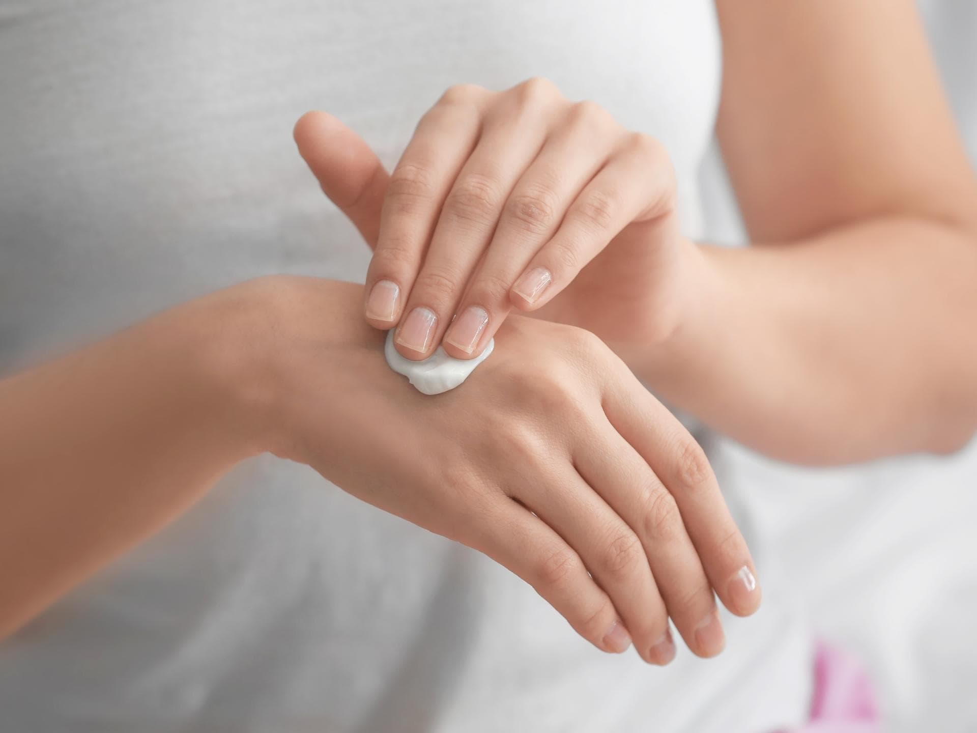 F>rau trägt Handlotion auf