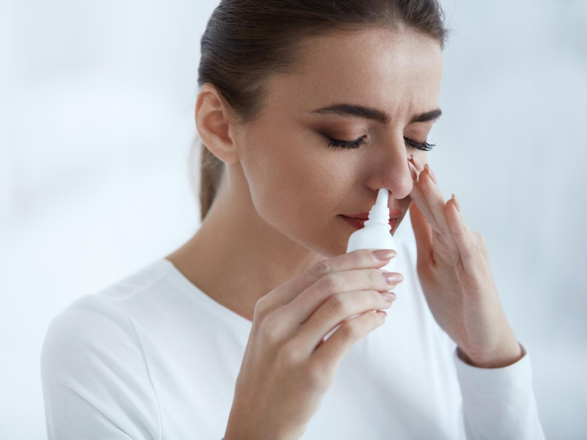 Frau nutzt Nasenspray