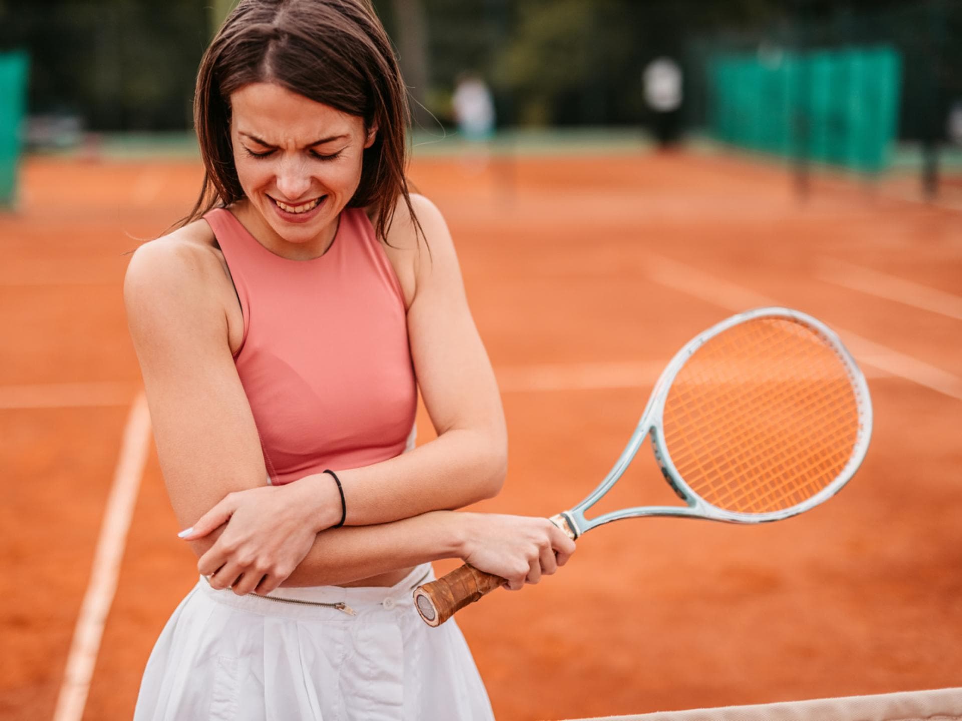 Tennisspielerin hält sich Arm