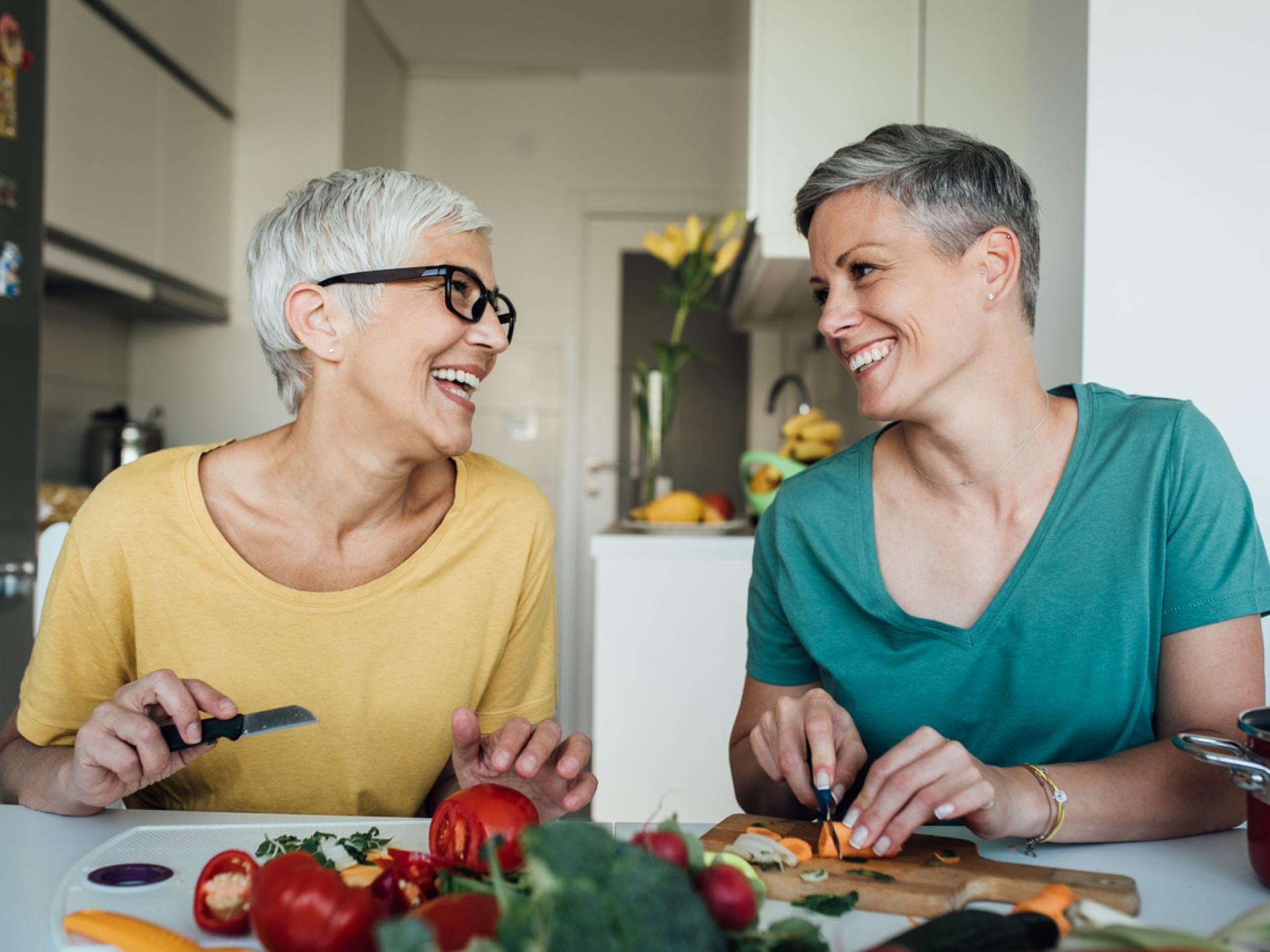 zwei reife Frauen bereiten Lebensmittel in Küche vor