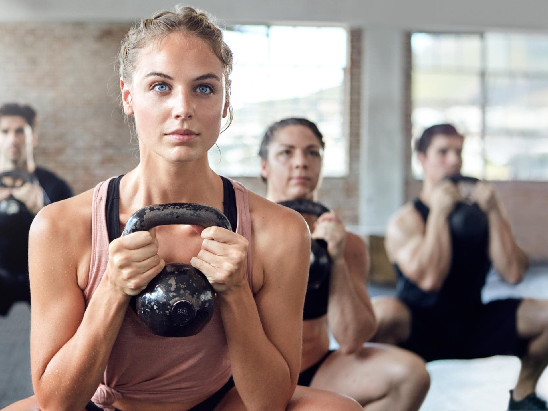 Never skip leg day Frau trainiert mit Kettlebell in Gruppe