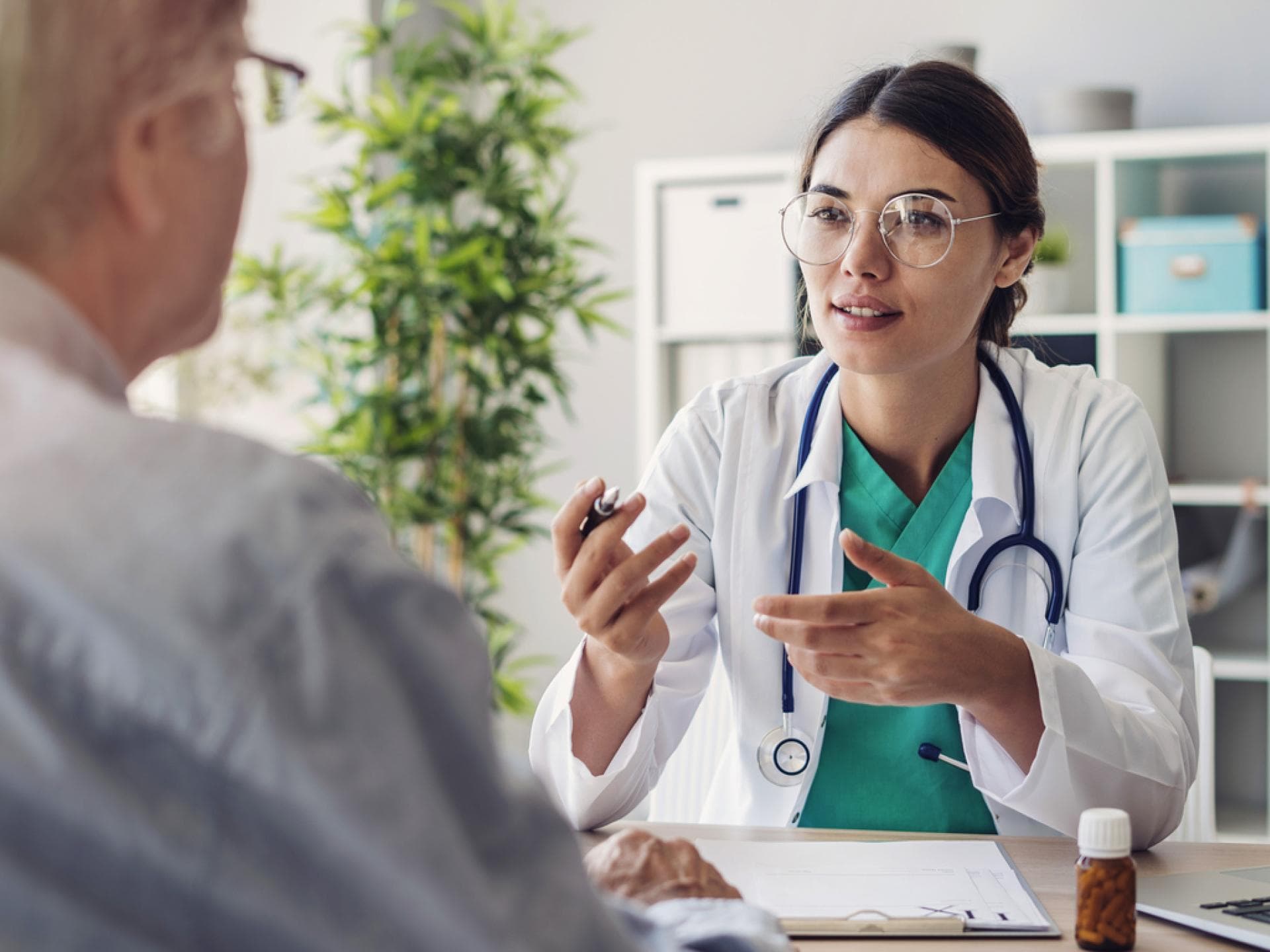 Ärztin im Patientengespräch mit älterem Mann