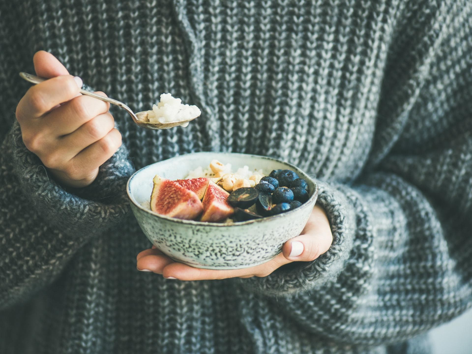 Frau isst Porridge im WInter