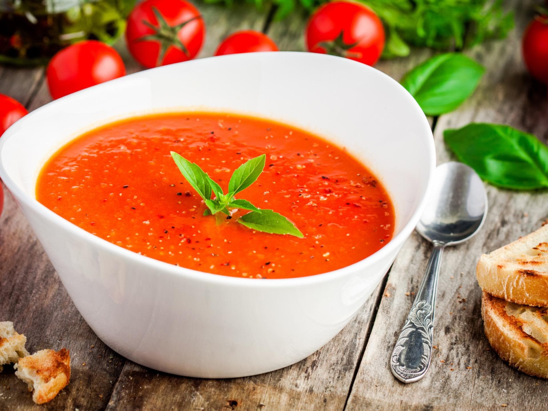 Tomatensuppe in Schüssel auf Holztisch